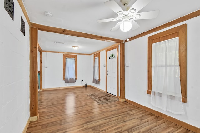 unfurnished room with wood finished floors, a ceiling fan, baseboards, and a smoke detector