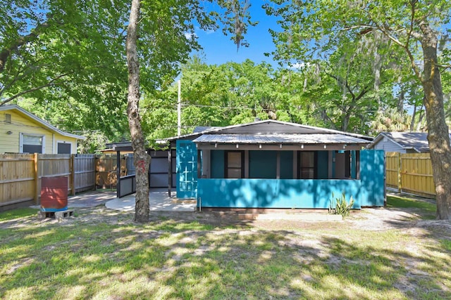 back of property with metal roof and view of wooded area