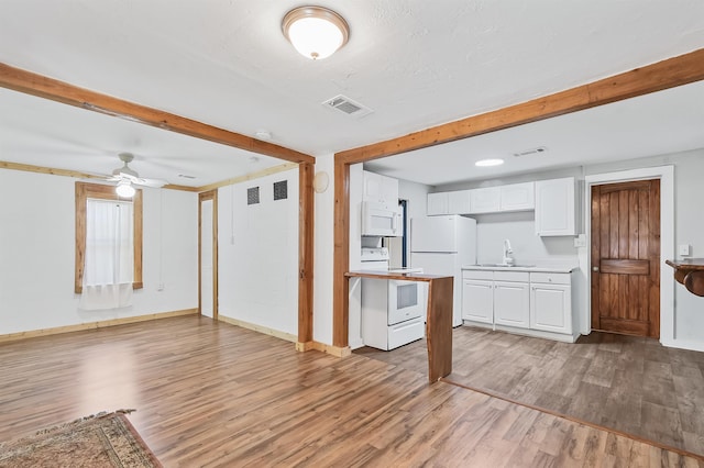 kitchen with white appliances, a sink, light wood-type flooring, light countertops, and white cabinetry