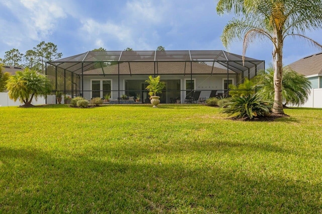 back of house with a lanai and a lawn