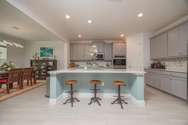 kitchen with a kitchen bar, a center island with sink, and gray cabinetry