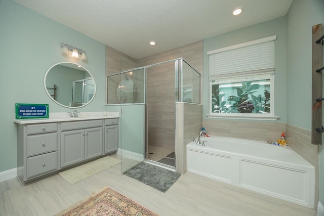 bathroom featuring vanity, shower with separate bathtub, and a textured ceiling