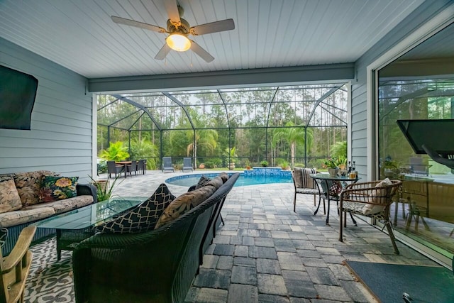 view of patio featuring ceiling fan and glass enclosure