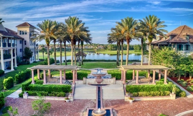 view of property's community with a water view and a pergola