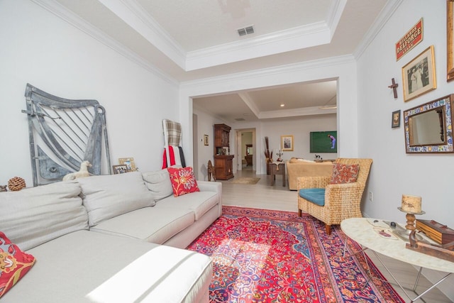 living room featuring ornamental molding, a tray ceiling, and wood-type flooring