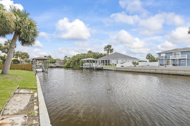 view of dock featuring a water view, a lawn, and fence