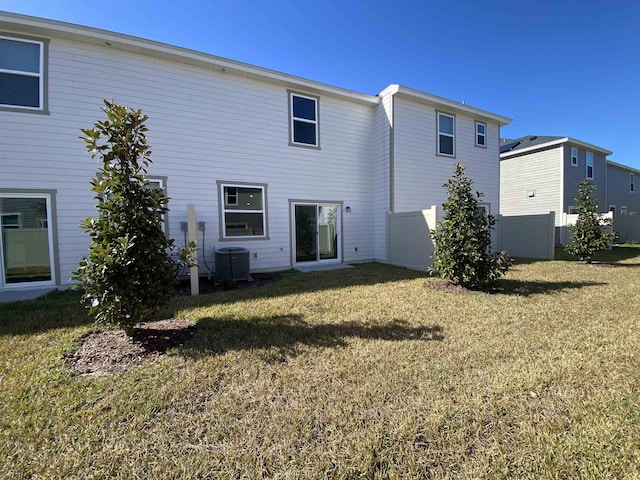 back of property featuring central AC and a lawn