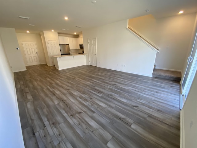 unfurnished living room with sink and hardwood / wood-style flooring