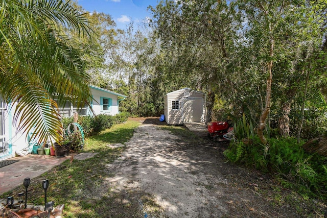 view of yard featuring a storage shed and an outdoor structure