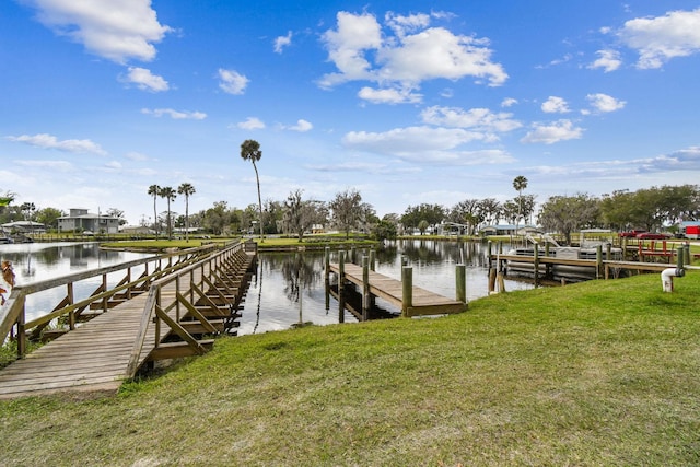 dock area featuring a lawn and a water view