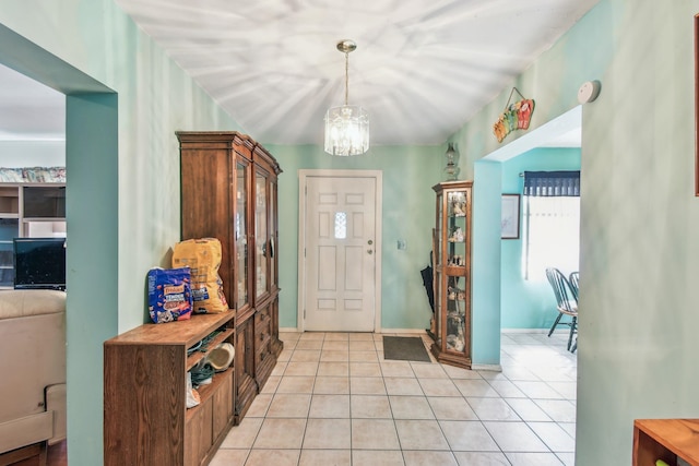 entryway with baseboards, an inviting chandelier, and light tile patterned floors