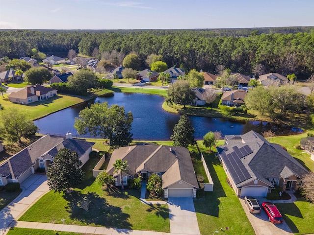 aerial view featuring a view of trees, a residential view, and a water view