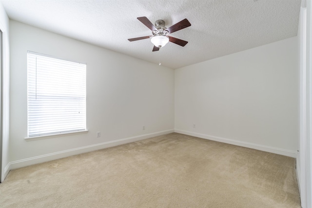 unfurnished room with baseboards, light colored carpet, a textured ceiling, and ceiling fan