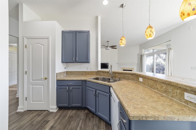 kitchen with a sink, ceiling fan, a textured ceiling, blue cabinets, and dark wood-style flooring