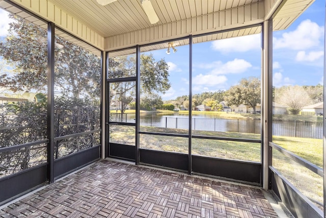 unfurnished sunroom with a water view and ceiling fan