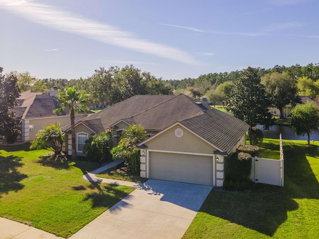 view of front of home with stucco siding, a gate, concrete driveway, a front yard, and a garage