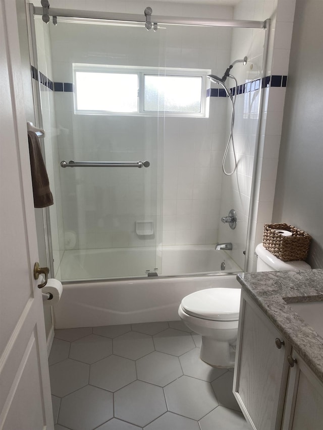 bathroom featuring tile patterned floors, toilet, vanity, and shower / bath combination with glass door