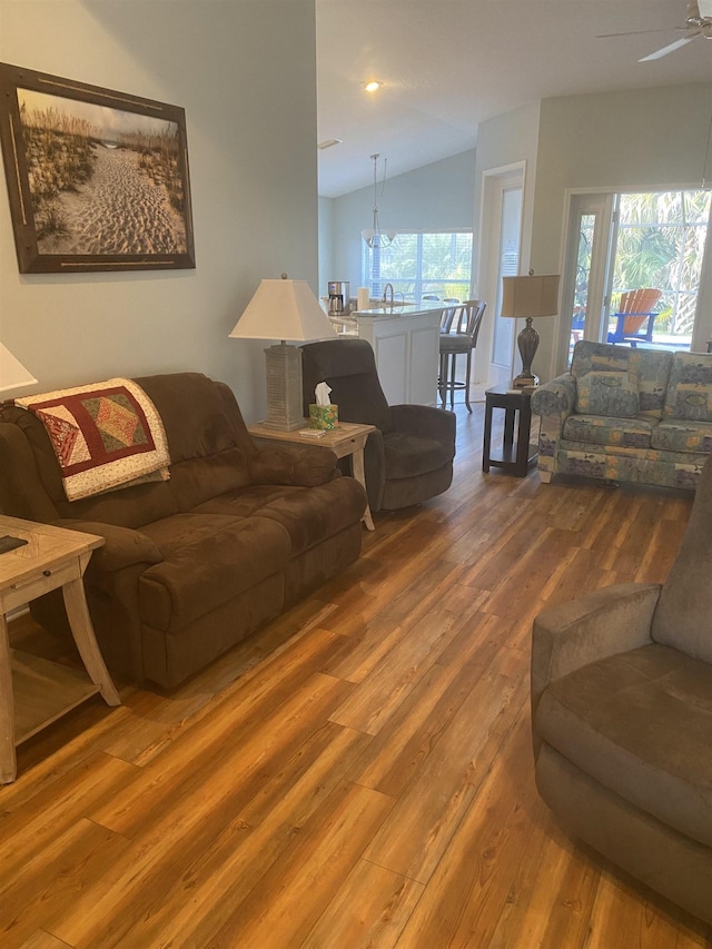 living room featuring a wealth of natural light, lofted ceiling, wood finished floors, and ceiling fan