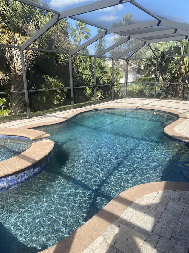 pool with a lanai and a patio area