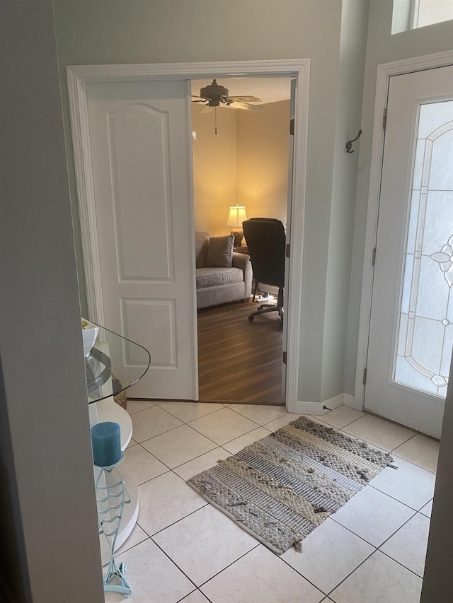 entrance foyer featuring light tile patterned floors, baseboards, and ceiling fan