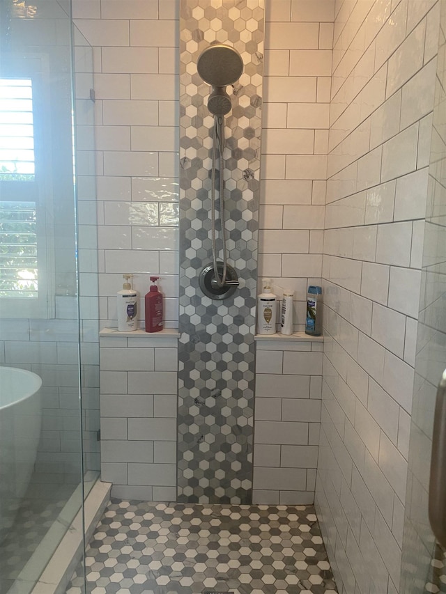 full bathroom featuring a freestanding bath and tiled shower