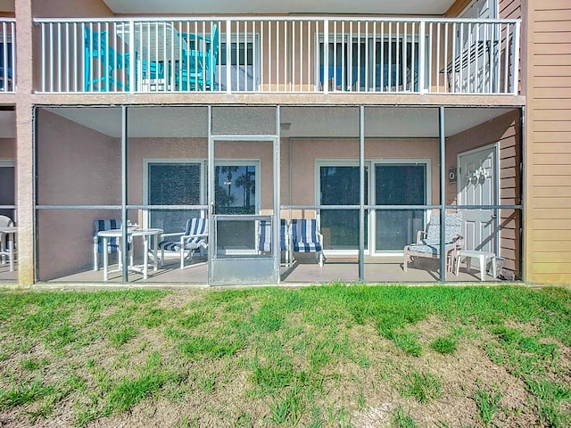 rear view of property featuring a patio and a lawn