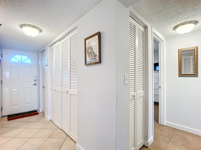 foyer featuring light tile patterned floors and a textured ceiling