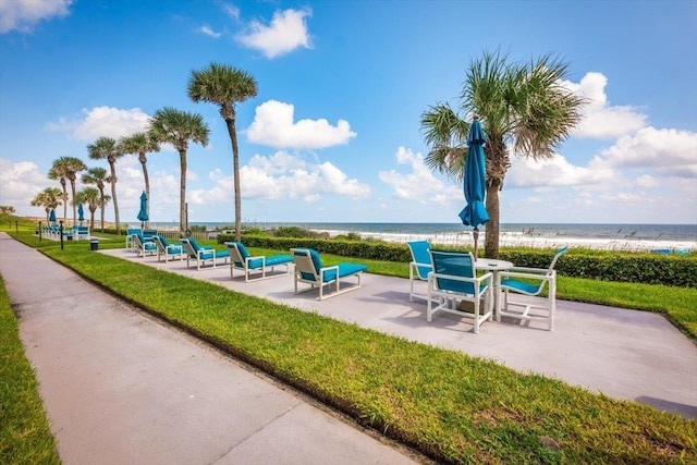 view of home's community featuring a water view and a beach view