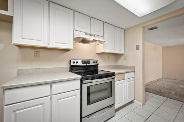 kitchen with light tile patterned floors, white cabinetry, and stainless steel electric range