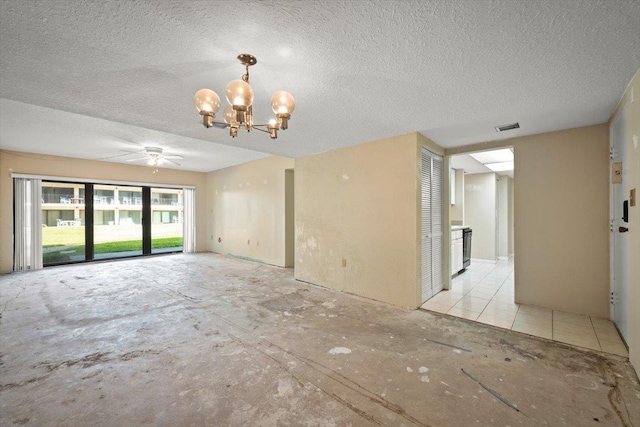 empty room featuring ceiling fan with notable chandelier and a textured ceiling