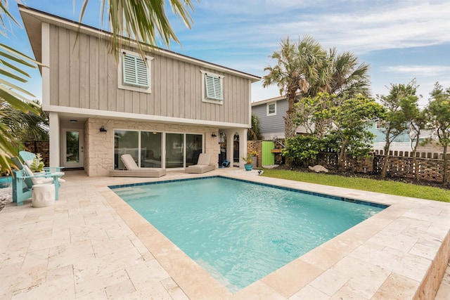 back of house with a fenced in pool and a patio