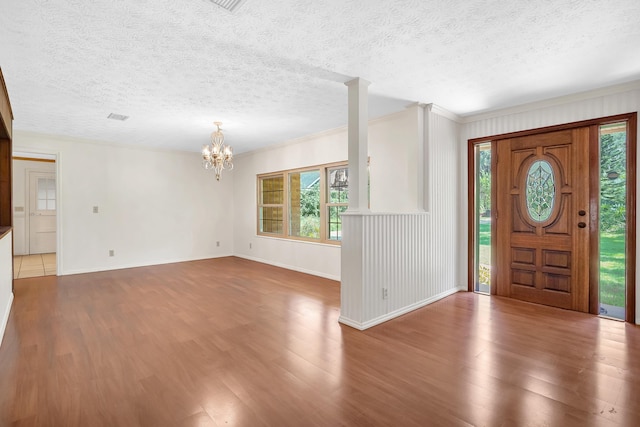 6433 Jack Wright Island Rd, Saint Augustine, FL 32092 - entrance foyer with a chandelier, healthy amount of natural light, wood finished floors, a textured ceiling, and ornamental molding