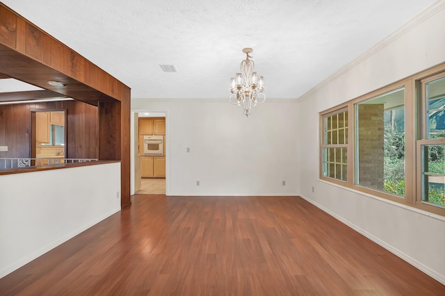 6433 Jack Wright Island Rd, Saint Augustine, FL 32092 - unfurnished living room featuring wood finished floors, a chandelier, a textured ceiling, and crown molding