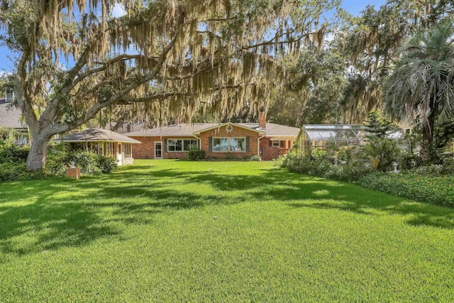 6433 Jack Wright Island Rd, Saint Augustine, FL 32092 - view of front of house with an exterior structure, a chimney, a front lawn, an outdoor structure, and brick siding