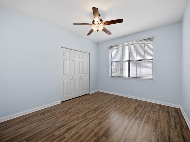 unfurnished bedroom with ceiling fan, dark hardwood / wood-style floors, and a closet