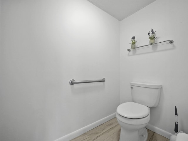 bathroom with hardwood / wood-style flooring and toilet