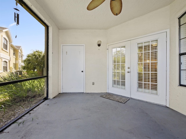 unfurnished sunroom featuring ceiling fan and french doors