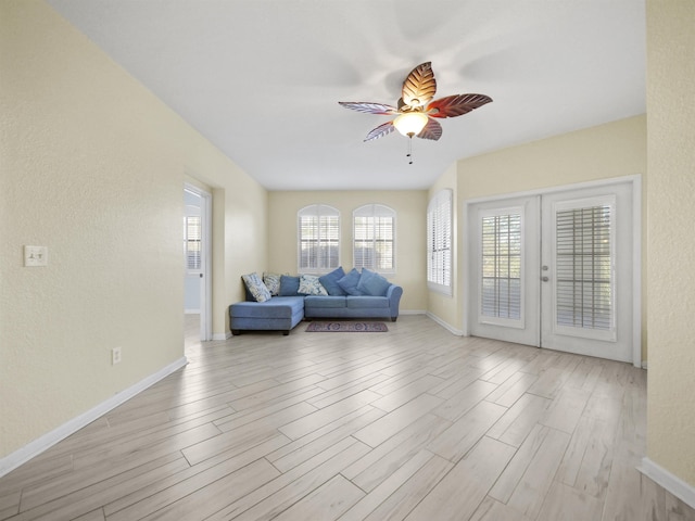 living room featuring ceiling fan, french doors, and light hardwood / wood-style floors