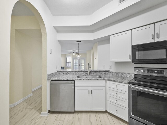 kitchen with white cabinetry, ceiling fan, sink, light stone countertops, and appliances with stainless steel finishes