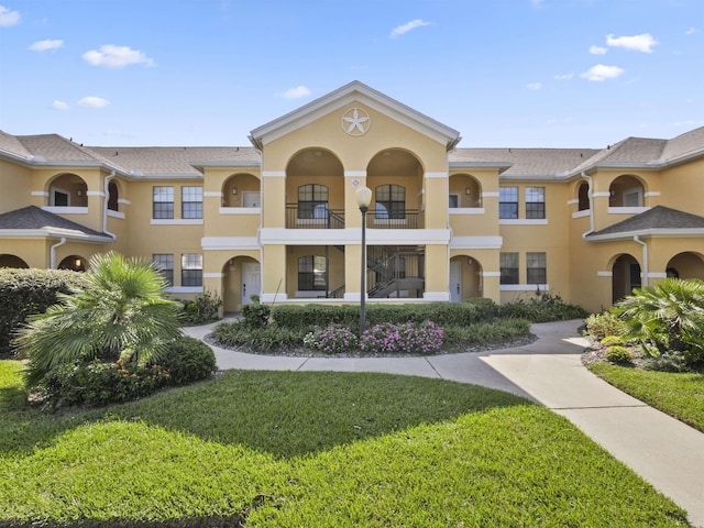 townhome / multi-family property featuring a front yard and a balcony