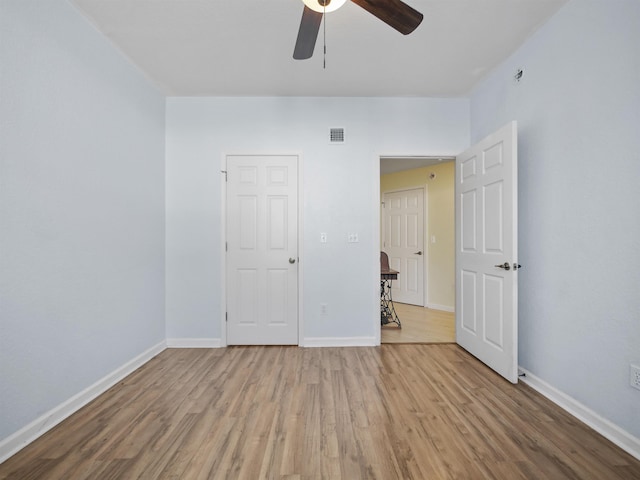 empty room with hardwood / wood-style floors and ceiling fan