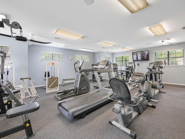 exercise room with ceiling fan and a healthy amount of sunlight