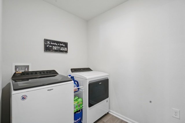 laundry room featuring washer and dryer, light wood-style flooring, and baseboards