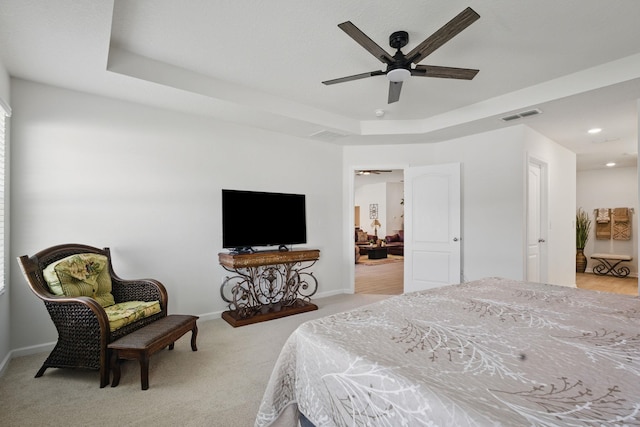 bedroom with light carpet, baseboards, a tray ceiling, recessed lighting, and a ceiling fan