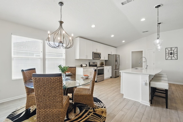 dining area featuring light wood finished floors, a chandelier, baseboards, lofted ceiling, and recessed lighting