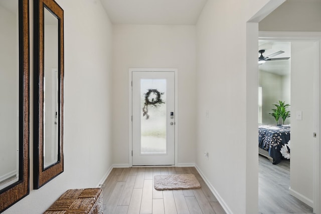 entrance foyer featuring light wood-style floors, ceiling fan, and baseboards