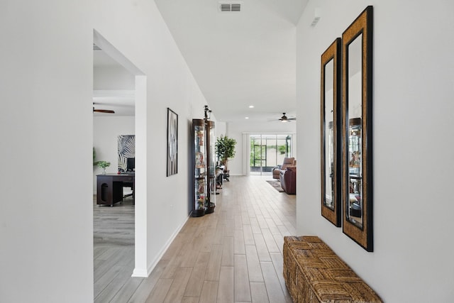hallway with light wood-type flooring, recessed lighting, an office area, and baseboards