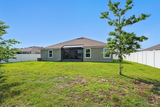 rear view of property featuring stucco siding, a sunroom, central air condition unit, and a shingled roof