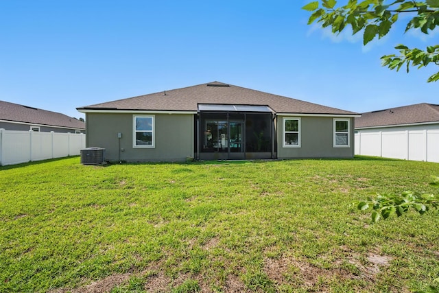 back of property with a sunroom, stucco siding, and a shingled roof