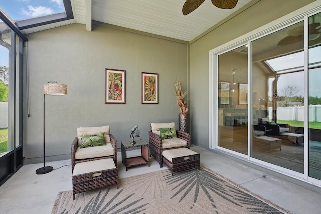 sunroom featuring a skylight, a ceiling fan, and an outdoor hangout area